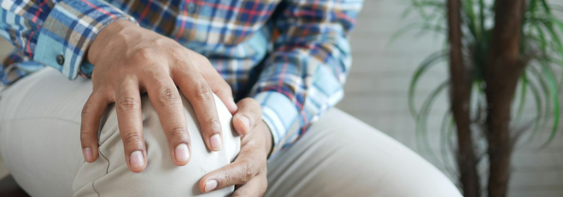 man holding knee due to pain